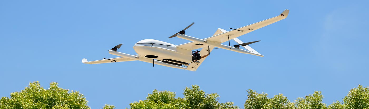 eVTOL aircraft flying over trees