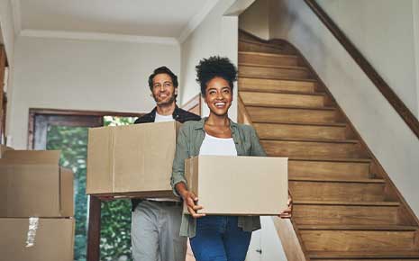 people bringing moving boxes into home
