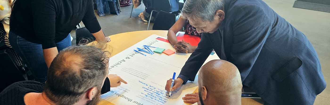 A man writes down comments at an OIPA community meeting in Omaha, NE