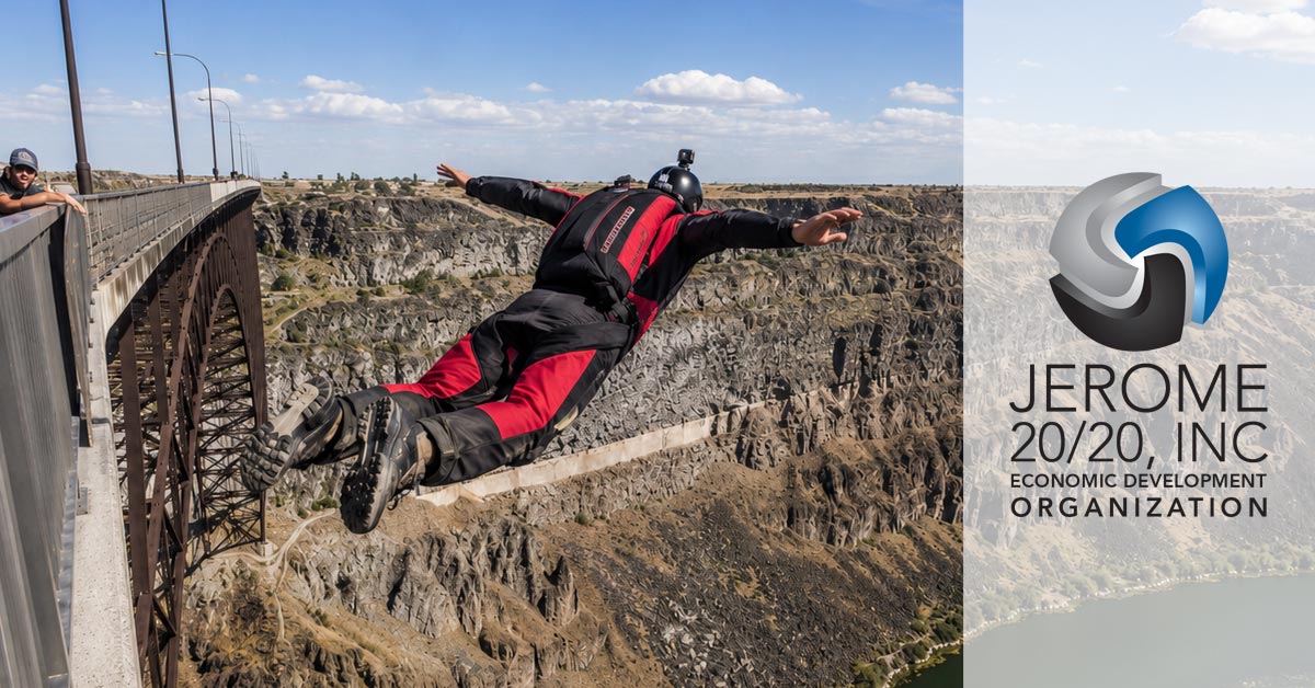 The image shows a person BASE jumping off the I.B. Perrine Bridge over the Snake River Canyon in Twin Falls, Idaho.