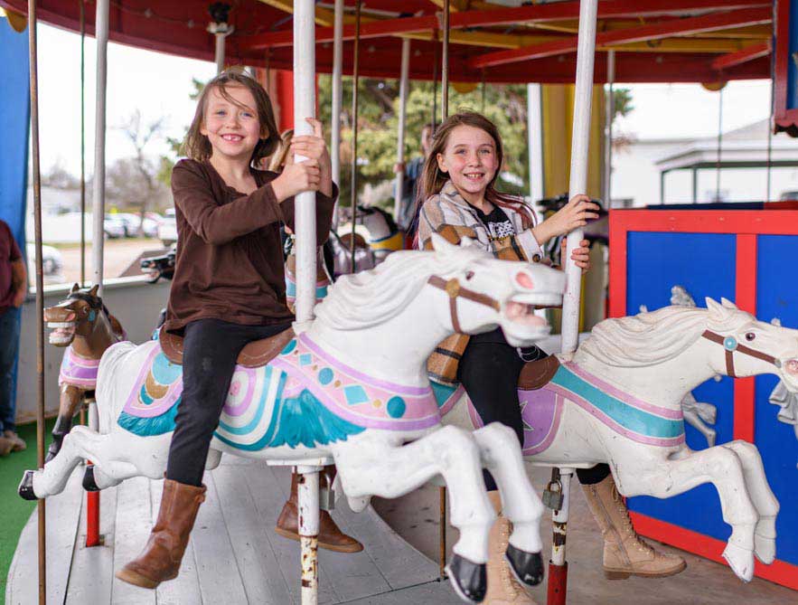girls riding a carousel