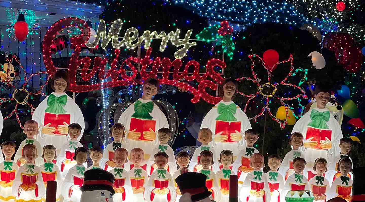 Illuminated Christmas choir display with Merry Christmas lights