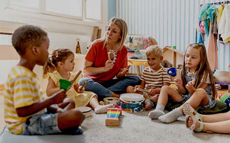 Preschool teacher engaging a group of children in a fun music activity