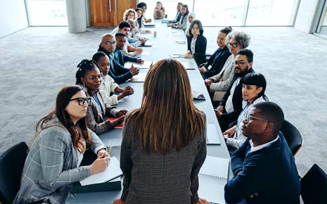 A council meeting with a group of diverse business people sitting at a larger table