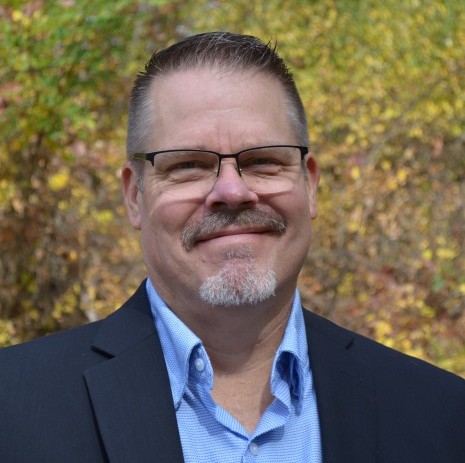 corporate headshot of Chad DeBoer, middle aged caucasion male with glasses, moustache and chin beard