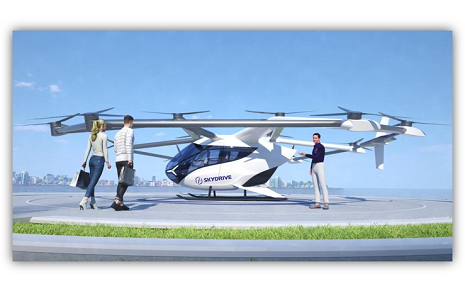 The image shows a conceptual rendering of the SkyDrive electric vertical takeoff and landing (eVTOL) aircraft, a three-seat air taxi developed by the Japanese company SkyDrive Inc.