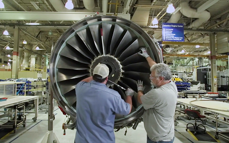The image shows workers assembling the fan module of a Rolls-Royce Trent turbofan jet engine.